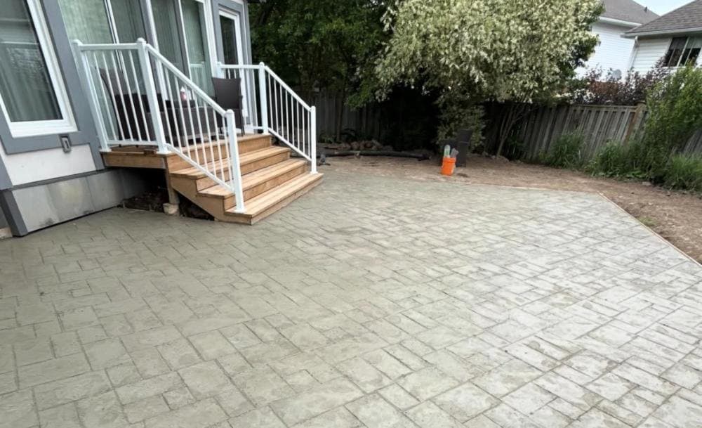 a large stamped concrete patio finished off a rear deck