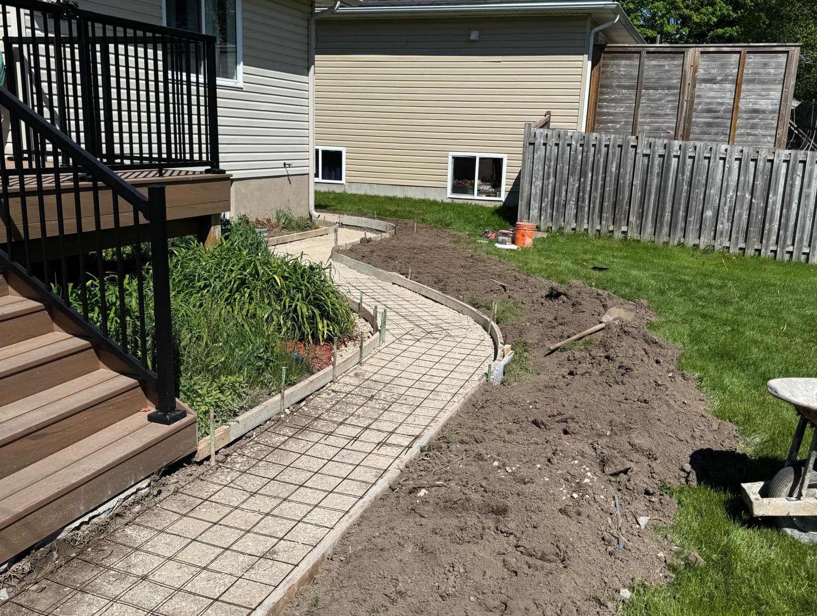 a radiused broom finished concrete walkway wrapping a house in Arthur, poured by Ironground