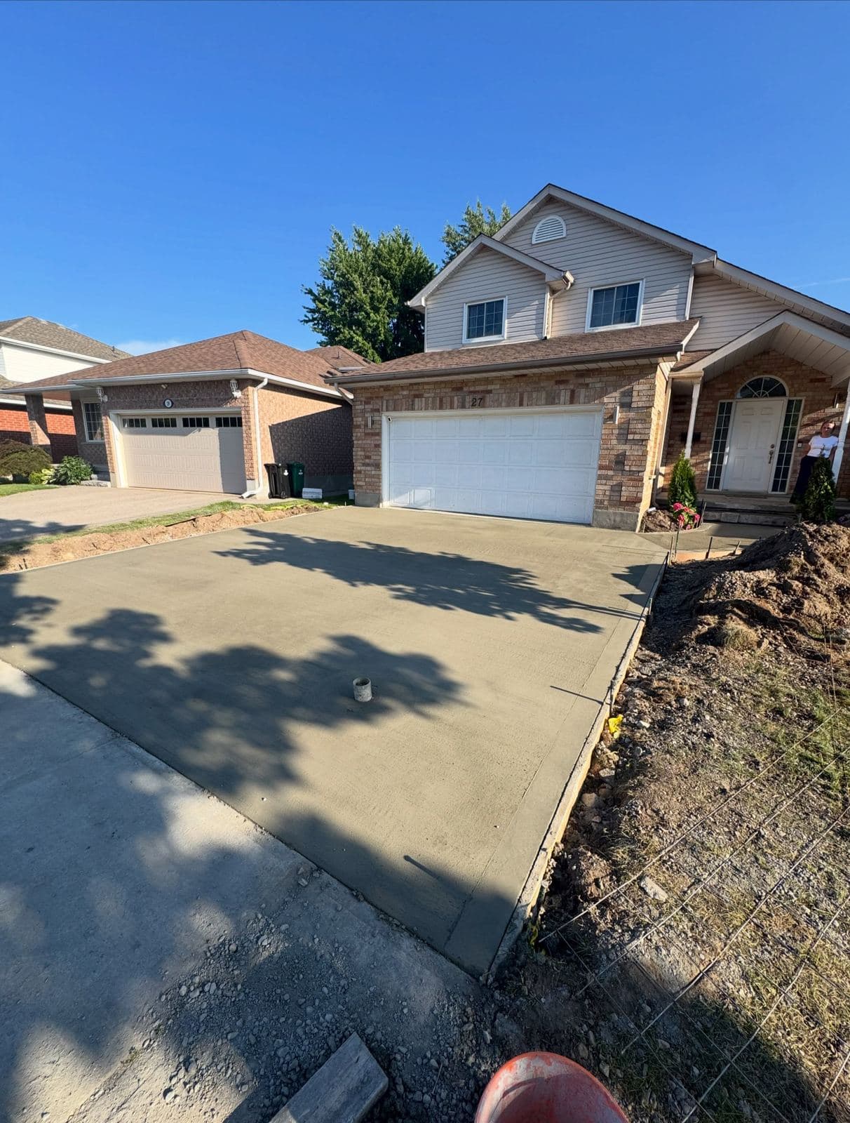 a new broom finished concrete driveway and front porch poured by Ironground on Gregg Court, Kitchener